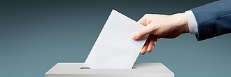 Kammerwahl 2026 Hand, die in Wahlurne Brief einwirft
